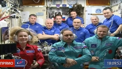 Actress Yulia Peresild, left, film director Klim Shipenko, right, and cosmonaut Anton Shkaplerov sit in the first row among other participants of the mission in the International Space Station. (AP)