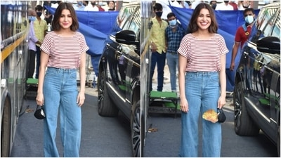 Anushka wore a crew neck half-sleeved top featuring white and red stripes, folded cuffs, and a baggy silhouette. The star tucked her blouse inside the denims to give a casual yet dressed-up touch. She teamed the top with high-waisted wide leg jeans in a light blue shade. (HT Photo/Varinder Chawla)