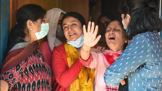 Relatives of pharmacist ML Bindroo mourn his death at his residence in Srinagar on Wednesday. Bindroo was shot dead Tuesday evening near his shop by militants in Jammu and Kashmir. (PTI)