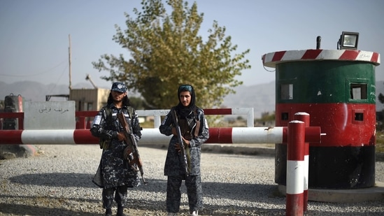 Taliban fighters working as a police force stand guard at the entrance gate of a police district in Kabul.(AFP Photo)
