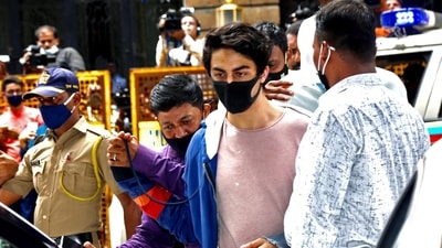 Aryan Khan, arrested in drugs case, being escorted at the NCB office after a medical check-up, in Mumbai on Wednesday. (ANI Photo) Aryan Khan, arrested in drugs case, being escorted at the NCB office after a medical check-up, in Mumbai on Wednesday. (ANI Photo)