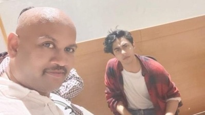 A man takes a selfie with Shah Rukh Khan's son Aryan Khan during the latter's questioning at NCB office in connection to a drug case. (ANI)