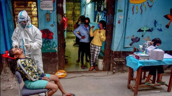A health worker collects sample from a girl for Covid-19 test at a Children’s Home in New Delhi. Under the ‘PM CARES for Children’ scheme, children who lost both their parents will be supported by the government. (PTI) A health worker collects sample from a girl for Covid-19 test at a Children’s Home in New Delhi. Under the ‘PM CARES for Children’ scheme, children who lost both their parents will be supported by the government. (PTI)