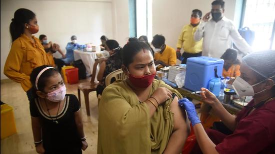 A healthcare worker inoculates a beneficiary against Covid-19 during a free vaccination camp at Ganesh Chowk, Andheri (West), in Mumbai. (HT PHOTO)