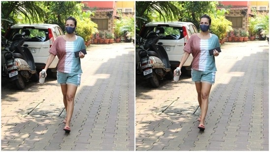 Malaika paired her multicoloured top with a casual chic soft blue pair of yoga shorts of the same print. She posed for the cameras outside her yoga studio.(HT Photos/Varinder Chawla)