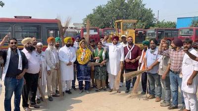 AAP leader Kulwant Sidhu, along with party workers, cleaning the dilapidated city buses in Ludhiana on Friday. (Harsimar Pal Singh/HT)
