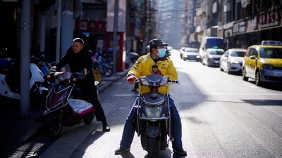 A Meituan delivery worker wearing a mask is seen on a street in Shanghai, China. (REUTERS)
