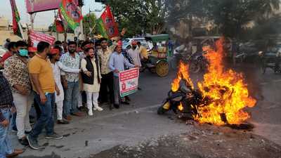 Rizwan Raisuddin ‘Prince’ (in black jacket), the vice president of Agra unit of Samajwadi Party burning scooter to protest hike in fuel prices in Agra on Friday. (HT photo)