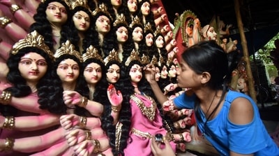 A young girl from Uttar Pradesh's Gorakhpur, can be seen painting Goddess Durga's eyebrows ahead of the main festival of Durga Puja. (PTI) A young girl from Uttar Pradesh's Gorakhpur, can be seen painting Goddess Durga's eyebrows ahead of the main festival of Durga Puja. (PTI)