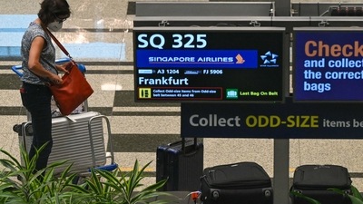A passenger on Singapore Airlines flight SQ325 -- the first flight to arrive under the new Vaccinated Travel Lane (VTL) -- is pictured in the baggage hall at Changi Airport in Singapore on September 8, 2021. (Photo by Roslan Rahman / AFP) (AFP)