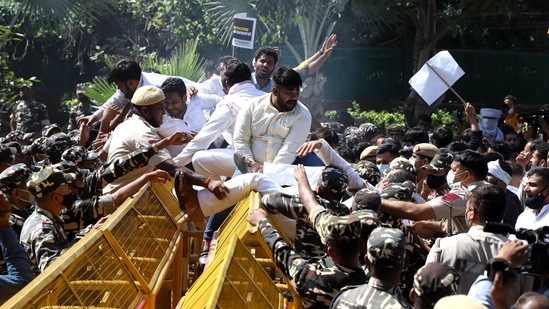 Youth Congress supporters climb over police barricades during a protest over the Lakhimpur Kheri incident near Union Home Minister's residence, in New Delhi on Saturday.&nbsp;(ANI)