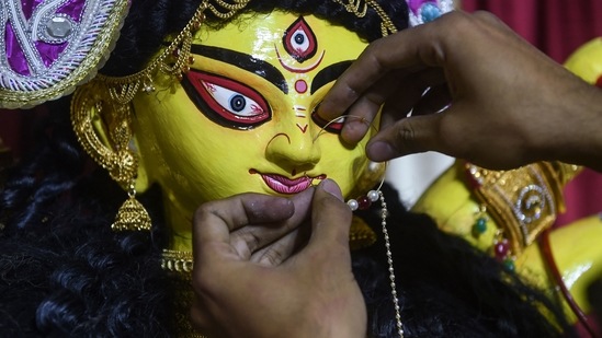 An artist from Ahmedabad decorates an idol of Goddess Durga with ornaments ahead of the main festival of Durga Puja. (AFP)