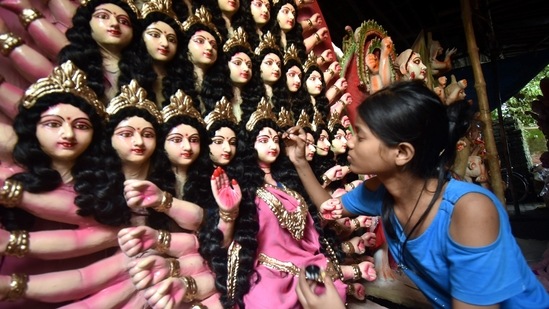 A young girl from Uttar Pradesh's Gorakhpur, can be seen painting Goddess Durga's eyebrows ahead of the main festival of Durga Puja.(PTI)