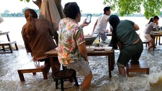 Customers of the riverside Chaopraya Antique Café react to a boat's wake (AP) Customers of the riverside Chaopraya Antique Café react to a boat's wake (AP)