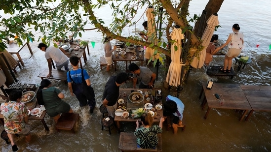 Customers of the riverside Chaopraya Antique Café react to a boat's wake as they enjoy themselves in the extraordinary high water levels in the Chao Phraya River in Nonthaburi(AP) Customers of the riverside Chaopraya Antique Café react to a boat's wake as they enjoy themselves in the extraordinary high water levels in the Chao Phraya River in Nonthaburi(AP)
