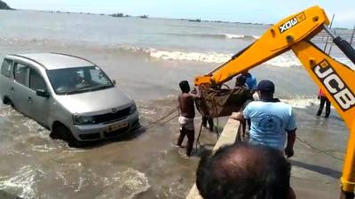 The car swept away with the high tide and locals managed to pull it out.
