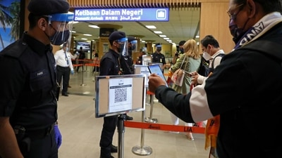 A tourist scans a QR code to check in upon arriving at the airport in Malaysia. (REUTERS/Lim Huey Teng/File Photo) (REUTERS)