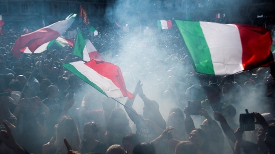 People wave national flags during a protest against the mandatory sanitary pass called “green pass” with the aim to limit the spread of the Covid-19 in central Rome on October 9, 2021.&nbsp;(AFP)
