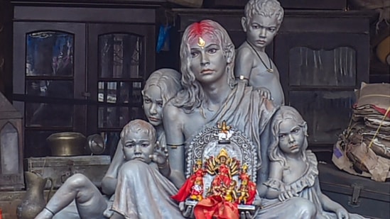 National Register of Citizens (NRC) themed idol: A statue of woman and children hold an idol of Goddess Durga, sit at a detention camp indicating NRC and CAA issues, at a community Durga Puja pandal in Kolkata.(PTI)