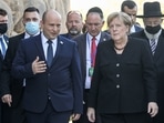 Israeli Prime Minister Naftali Bennett (C-L) speaks with German Chancellor Angela Merkel (C-R) as he escorts her outside at the Yad Vashem Holocaust Museum in Jerusalem