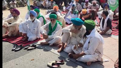 Farmers blocking a road in Sangrur against the power outages on Monday. (HT Photo)