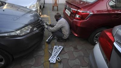 A mechanic replacing a car’s old registration number plate with the high security registration plate (HSRP) in Noida. (HT Archive)