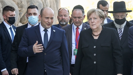 Israeli Prime Minister Naftali Bennett (C-L) speaks with German Chancellor Angela Merkel (C-R) as he escorts her outside at the Yad Vashem Holocaust Museum in Jerusalem(AFP)