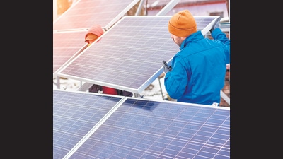 Technicians in blue suits mounting photovoltaic solar panels on roof of modern house. Building climate action into every new construction design is the need of the hour. (Shutterstock (FOR REPRESENTATIONAL PURPOSE)) Technicians in blue suits mounting photovoltaic solar panels on roof of modern house. Building climate action into every new construction design is the need of the hour. (Shutterstock (FOR REPRESENTATIONAL PURPOSE))