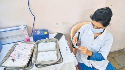 A health worker prepares a vaccine bottle for Covid vaccination in Pune. As of Tuesday, Pune district has reported 497 new Covid cases and six deaths due to the infection. (HT)