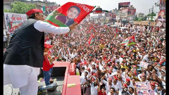 Samajwadi Party (SP) President Akhilesh Yadav holds a party flag while waving to supporters during Vijay Rath Yatra for 2022 Assembly elections, in Kanpur on Tuesday. (ANI Photo)