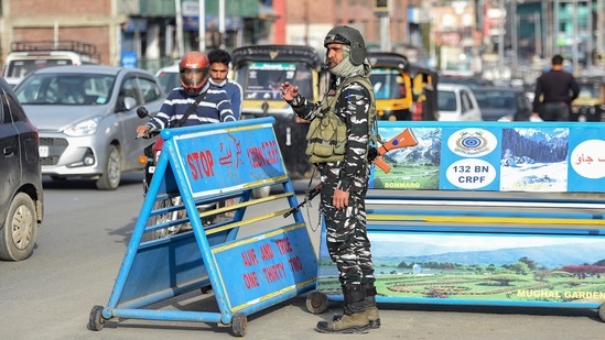 A security personnel stands guard at a check point, in Srinagar on Monday.(PTI Photo)