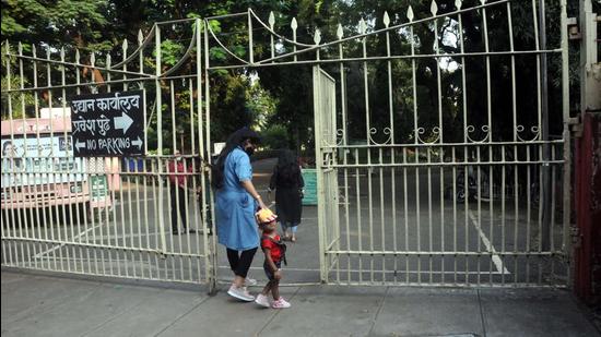 A woman and child enter a garden in Pune. Demand to reopen all gardens, extend timings grows louder in the city. (HT)