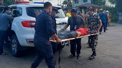 Police and army personnel carry an injured passenger to a hospital in Nepalgunj, some 650 km west of Kathmandu on October 12, 2021, after being airlifted from the Mugu region.&nbsp; (AFP)