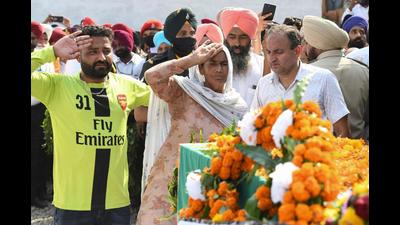The mother of Naik Mandeep Singh saluting the coffin of the soldier slain in Poonch encounter at at his native village Chatha in Gurdaspur district.