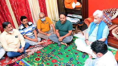 Jammu and Kashmir L-G Manoj Sinha interacts with the bereaved family members of the schoolteacher who was killed by militants, in Jammu on Wednesday. (ANI)