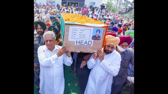 Punjab chief minister Charanjit Singh Channi (right) and assembly Speaker Rana KP Singh carrying the body of sepoy Gajjan Singh, 26, for the funeral held with full military honours at Pachranda village in Nurpur Bedi of Ropar district on Wednesday. (HT Photo)
