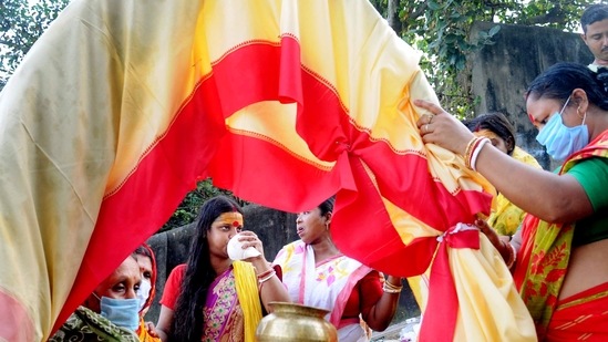Devotees perform rituals of ‘Kola Bou snan’ near Ganga river on the occasion of Maha Saptami, in Kolkata on October 12.(ANI)