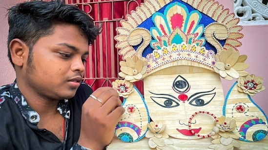 An artist named Biswajeet Nayak makes Maa Durga's face using a total of 275 ice cream sticks on the occasion of Maha Ashtami, in Puri.(ANI)