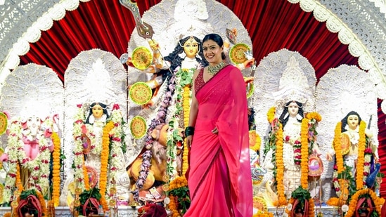 Kajol struck a pose with the idol of Goddess Durga for the shutterbugs on the seventh day of the 10-day long Durga Puja festival at North Bombay's Sarbojanin Durga Puja Samiti on October 12.(PTI)