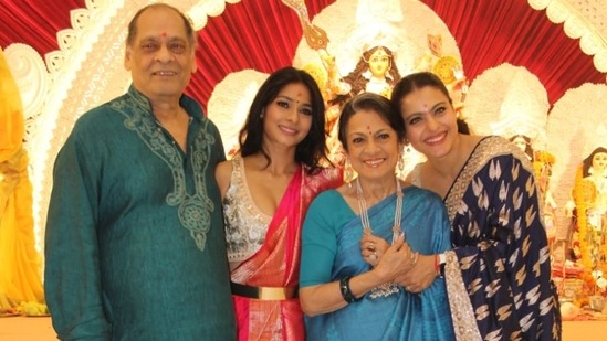 Kajol poses for photos with her family.