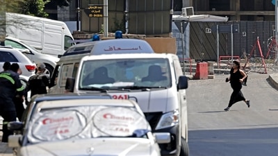 A woman crosses a road towards Lebanese medics during clashes in the area of Tayouneh, in the southern suburb of the capital Beirut. (AFP)