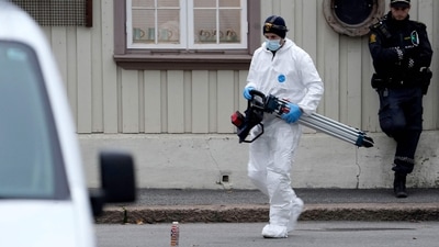 A police forensic carries material during investigations after a man armed with a bow and arrows killed 5 people before being arrested by police in Kongsberg. (AFP)