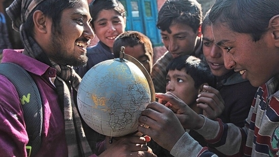 Kashmir: Close to the Line of Control between India and Pakistan, a group of Kashmiri children try to spot their village on a globe gifted to their school by a visiting NGO.(Photo: Vijay S Jodha )