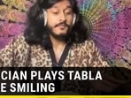 MUSICIAN PLAYS TABLA WHILE SMILING 