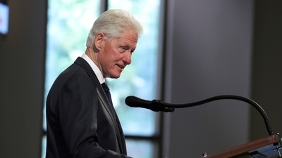 Clinton was in good spirits and juggling books and watching TV coverage about his hospitalization (via REUTERS)