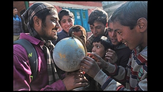 Kashmir: Close to the Line of Control between India and Pakistan, a group of Kashmiri children try to spot their village on a globe gifted to their school by a visiting NGO.(Photo: Vijay S Jodha)