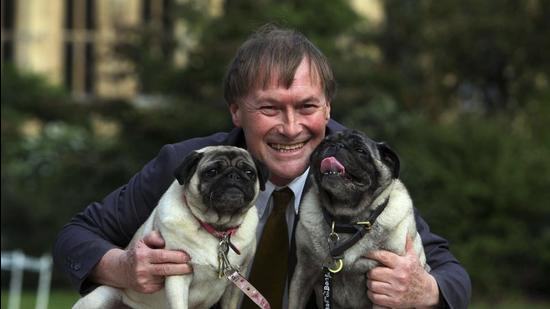 British Conservative lawmaker David Amess with his pugs, Lily and Boat at the Westminster Dog of the Year competition at Victoria Tower Gardens in London in October, 2013. Amess was killed on Friday after being stabbed “multiple times” during an event in his local constituency in southeast England. (AP)