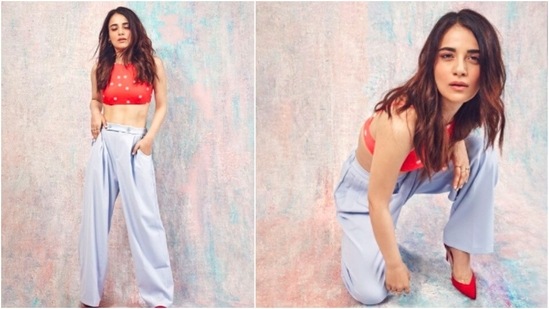 Radhika Madan, who can ace any outfit that she dons, recently shared a few stills of herself in a red and white polka-dotted crop top and light grey baggy pants.(Instagram/@radhikamadan)