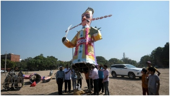 Devotees help in installing the effigies.(HT Photos/ Ravi Kumar)