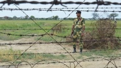 A BSF jawan patrolling the barbed fence on the Indo-Pakistan border in Punjab. A BSF jawan patrolling the barbed fence on the Indo-Pakistan border in Punjab.